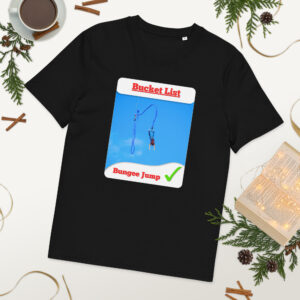Black T-shirt laid flat featuring a graphic card that says 'Bucket List' with a bungee jump image, surrounded by holiday decor on a white background.